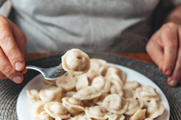 Adult man eats dumplings. Male hands.