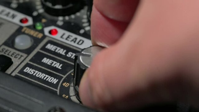 Man adjusting sound knobs on guitar amplifier. 4k video footage UHD 3840x2160