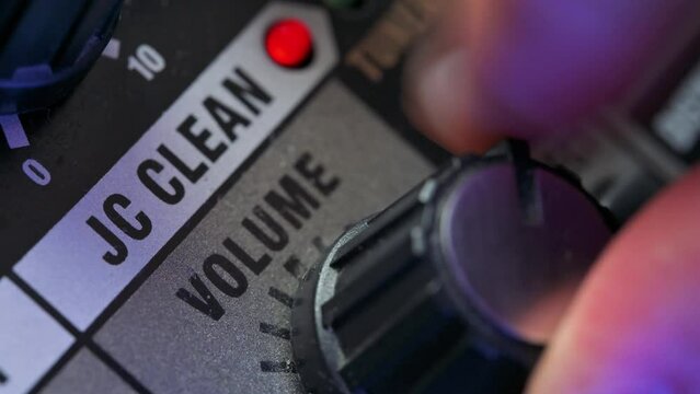 Man tuning volume knob on guitar amplifier. 4k video footage UHD 3840x2160