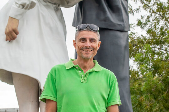A happy man in front of Unconditional Surrender Statue in Sarasota, Florida