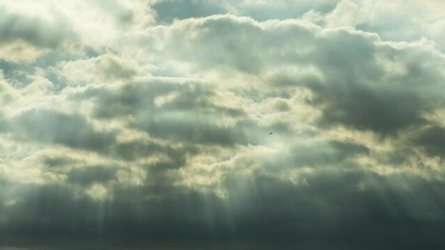 Fast moving gloomy clouds with the wind in the sky and sun rays. Time lapse. 4k footage UHD 3840x2160 