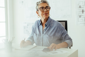 Project planning: Pensive interior designer making a to do list in her offfice