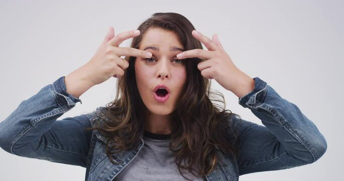 Crazy expression, face of woman in studio with funny and positive attitude for meme, post or comedy. Goofy emoji, silly performance and portrait of happy person with comic facial on white background.