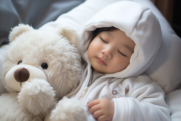 A small asian child sleeps in bed on a white background. Sweet, restful dreams