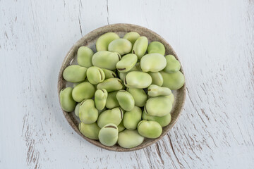 top view raw green broad beans on wooden table