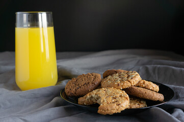 orange juice and cookies on a dark background.
