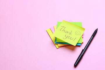 Thank You sticky notes with pen on pink background