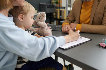 Young mother filing documents for adoption during her visit to social service