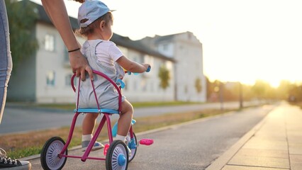 mother teaches daughter to ride. happy family kids dream concept. young mother teaches her daughter...