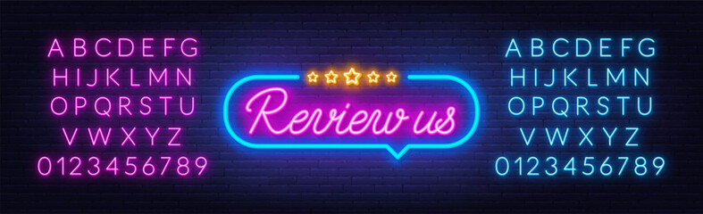 Review Us neon sign in the speech bubble on brick wall background. - obrazy, fototapety, plakaty