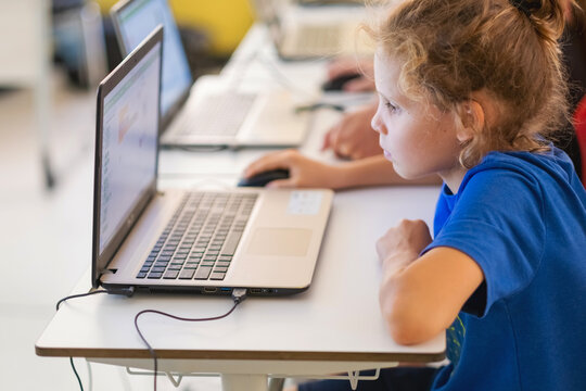 Students working at laptop computers in classroom of elementary school