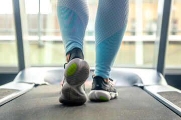 Woman's legs on a treadmill, shoes close-up, cardio workout. - obrazy, fototapety, plakaty