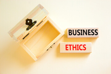 Business ethics symbol. Concept words Business ethics on beautiful wooden blocks. Beautiful white table white background. Empty beautiful wooden chest. Business ethics concept. Copy space.