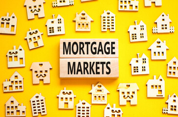Mortgage markets symbol. Concept words Mortgage markets on beautiful wooden blocks. Beautiful yellow table yellow background. House model. Business mortgage markets concept. Copy space.