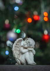A Christmas angel and a decorated Christmas tree in the background