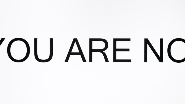 The sentence "YOU ARE NOT ALONE" is on the OLED screen. Concept of encouragement.