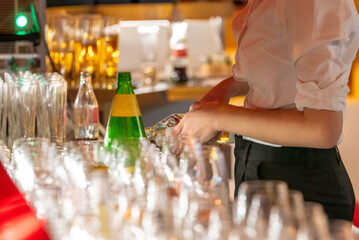 waitress pours water in glasses at an evenening event