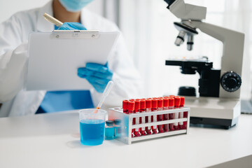 Fototapeta premium Female scientist researcher conducting an experiment working in the laboratory