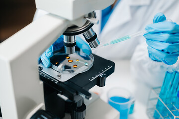 female scientist working with micro pipettes analyzing biochemical samples, advanced science laboratory