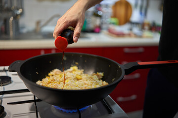 Man's hands making fried rice in a wok