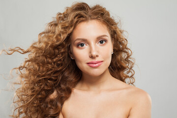 Naklejka premium Cute woman fashion model with long wavy hairstyle, natural makeup and clear skin. Haircare, facial treatment and skincare concept