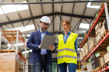 Female warehouse worker talking with production manager, discussing new order, preparing products...