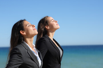 Two executives relaxing breathing on the beach