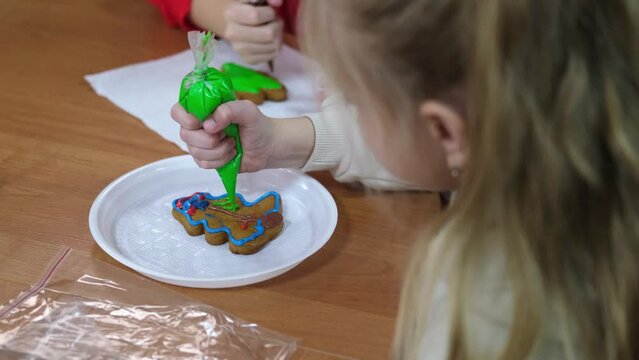 Master class on making Christmas ginger strands. Children paint gingerbread cookies with icing.