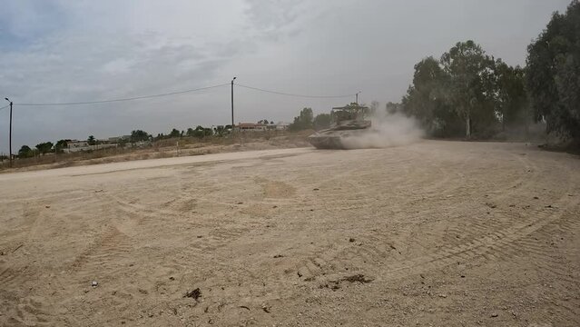 An Israeli Merkava tank in Gaza creating a dust cloud as advances through desert