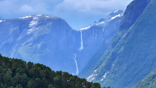 The drone zooms in and rises slowly behind mountains and Mardalsfossen in Eikesdal comes into view. The waterfall is one of the tallest waterfalls in Europe. A whopping 705 meters of waterfalls.