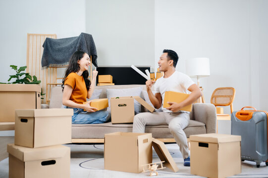 Asian young attractive couple man and woman use tablet and smartphone online shopping furniture decorate house with carton package move in new house. Young married asian moving home. .