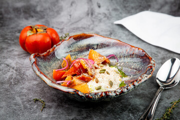 side view of a dish of baked persimmons, colored peppers, rice and seeds