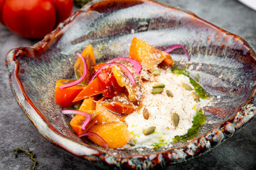 side view of a dish of baked persimmons, colored peppers, rice and seeds