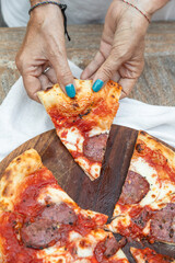 Hand with pepperoni pizza