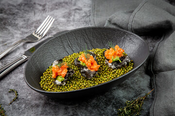 black caviar, red fish and wassabi on a plate with peas, top view