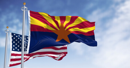 Flags of Arizona and United States waving in the wind on a clear day
