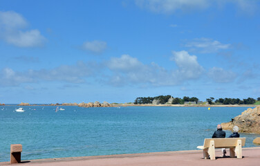 Un couple qui est assis face à la mer en Bretagne-France