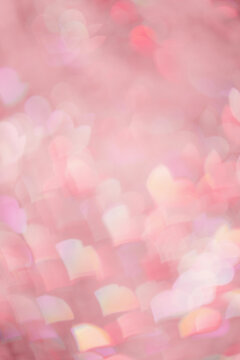 Abstract bokeh background pink color, natural flare from lights as hearts, pink monochrome photo, optical effect, blurred bokeh texture as romance holiday backdrop, celebration screensaver