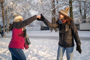 Winter Joy: Female Friends Dancing in Snowy Park Landscape