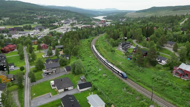 A train runs through Berkåk, Rennebu Municipality in Trøndelag county