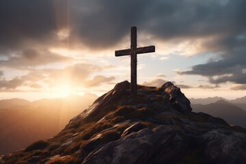 A cross stands tall on top of a mountain, illuminated by the vibrant colors of a sunset. Perfect for religious or inspirational content - obrazy, fototapety, plakaty