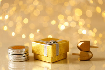 Jewish holiday Hanukkah with gift box, wooden dreidelsand chocolate coins. Golden baner