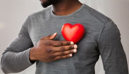 black man holding red heart on his chest