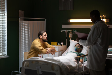 Man stays by the unconscious girl's side in the hospital and African doctor stands near woman and...