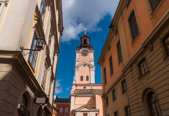 European street in the historic center of Gamla Stan overlooking the Bell Tower of The Cathedral Church of Saint Nicholas (Storkyrkan). Stockholm, Sweden.