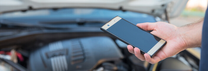 Hand of car mechanic holding phone