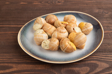Grape (Burgundy) snails with butter and cheese on brown wooden, side view © zgurski1980