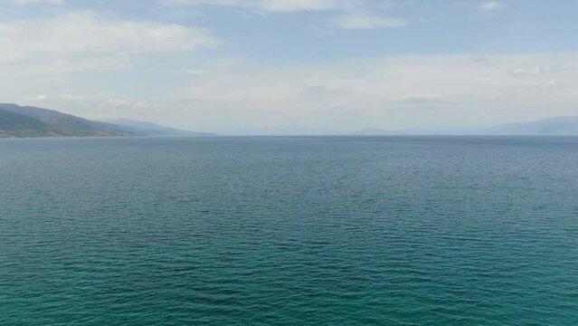 Drone view in Albania flying over Ohrid lake top view crystal clear water and green mountains