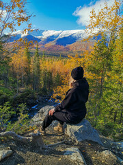 A girl on the background of an autumn Arctic landscape in the Khibiny mountains. Kirovsk, Kola...