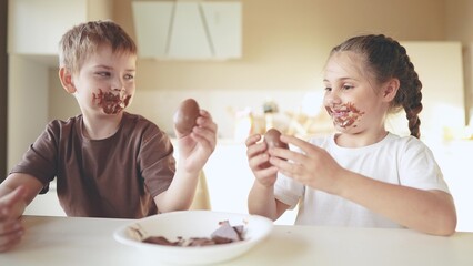 baby boy and girl eat chocolate. dirty little baby kids in the kitchen eating chocolate in the...
